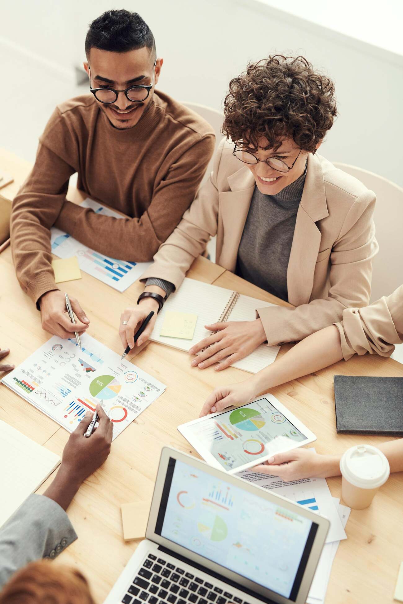 A group of professionals collaborating at a table, reviewing charts and graphs