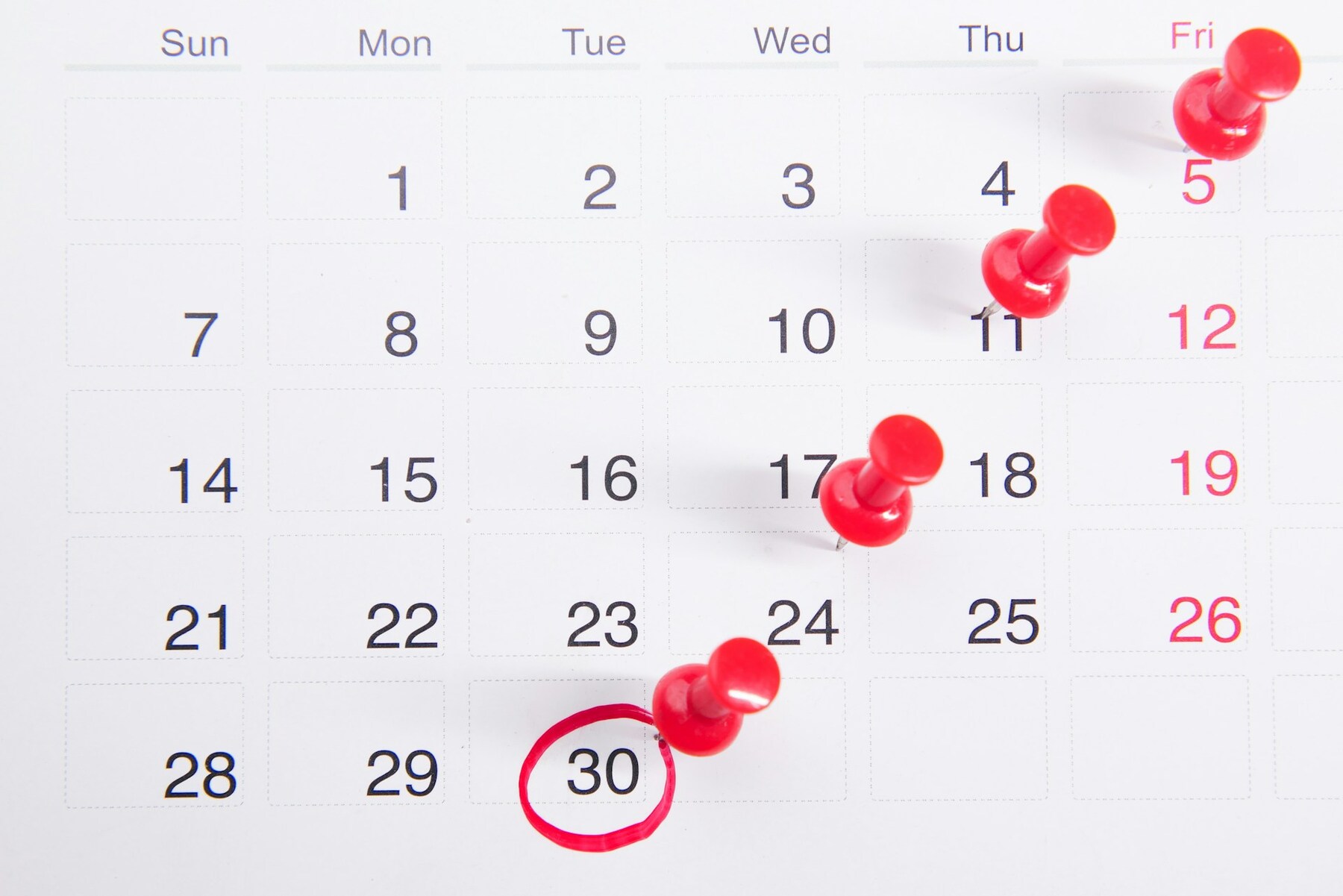 A calendar page marked with red pins indicating specific dates for important events or reminders