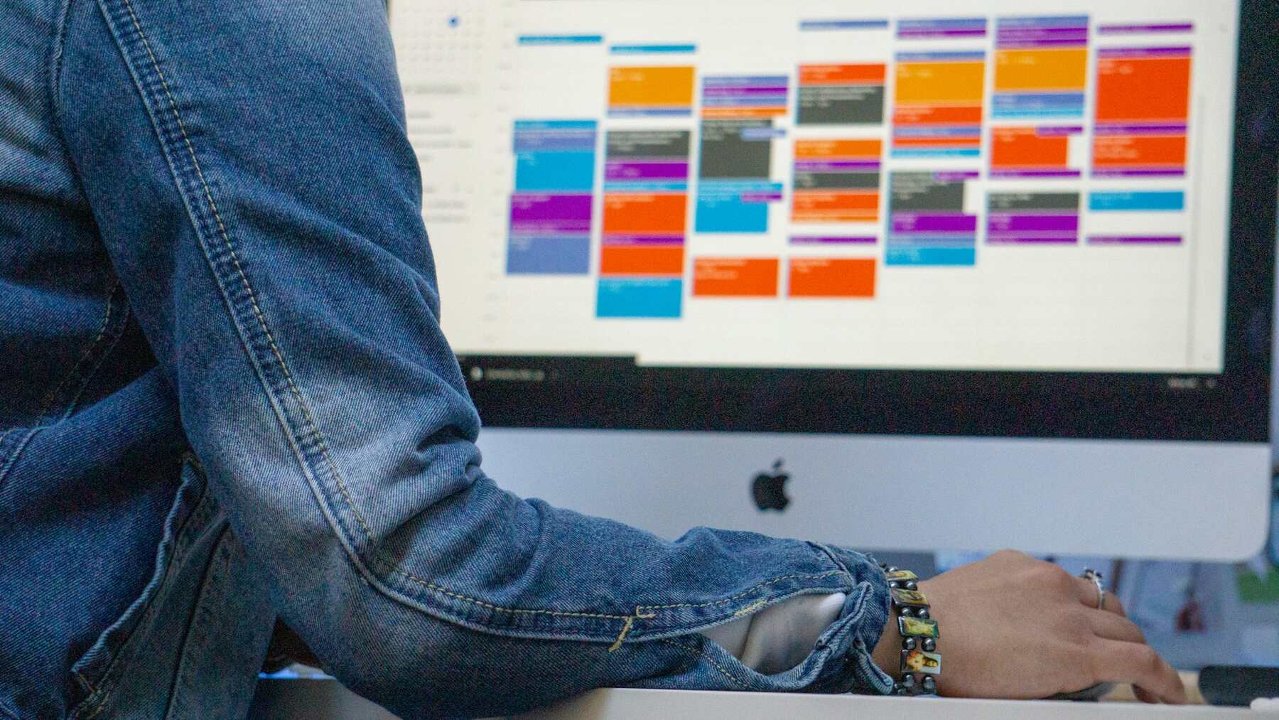 A woman seated at a desk, focused on a computer screen