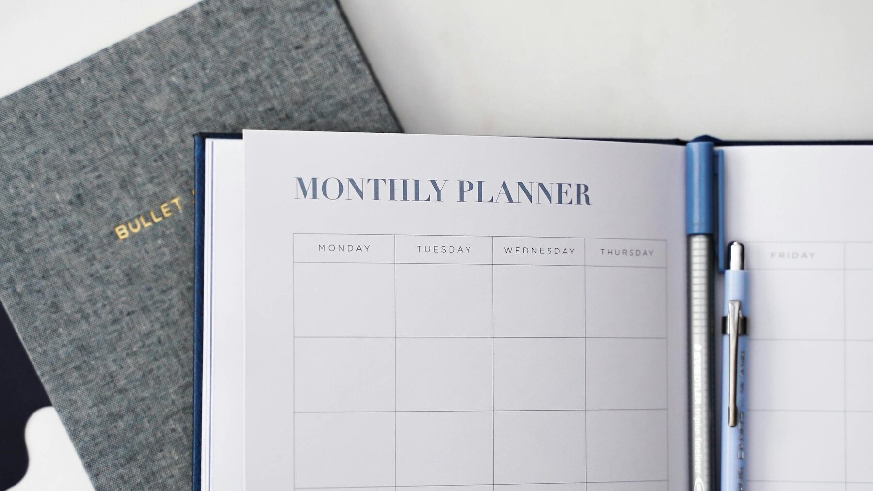 A monthly planner displayed on a desk in an office setting
