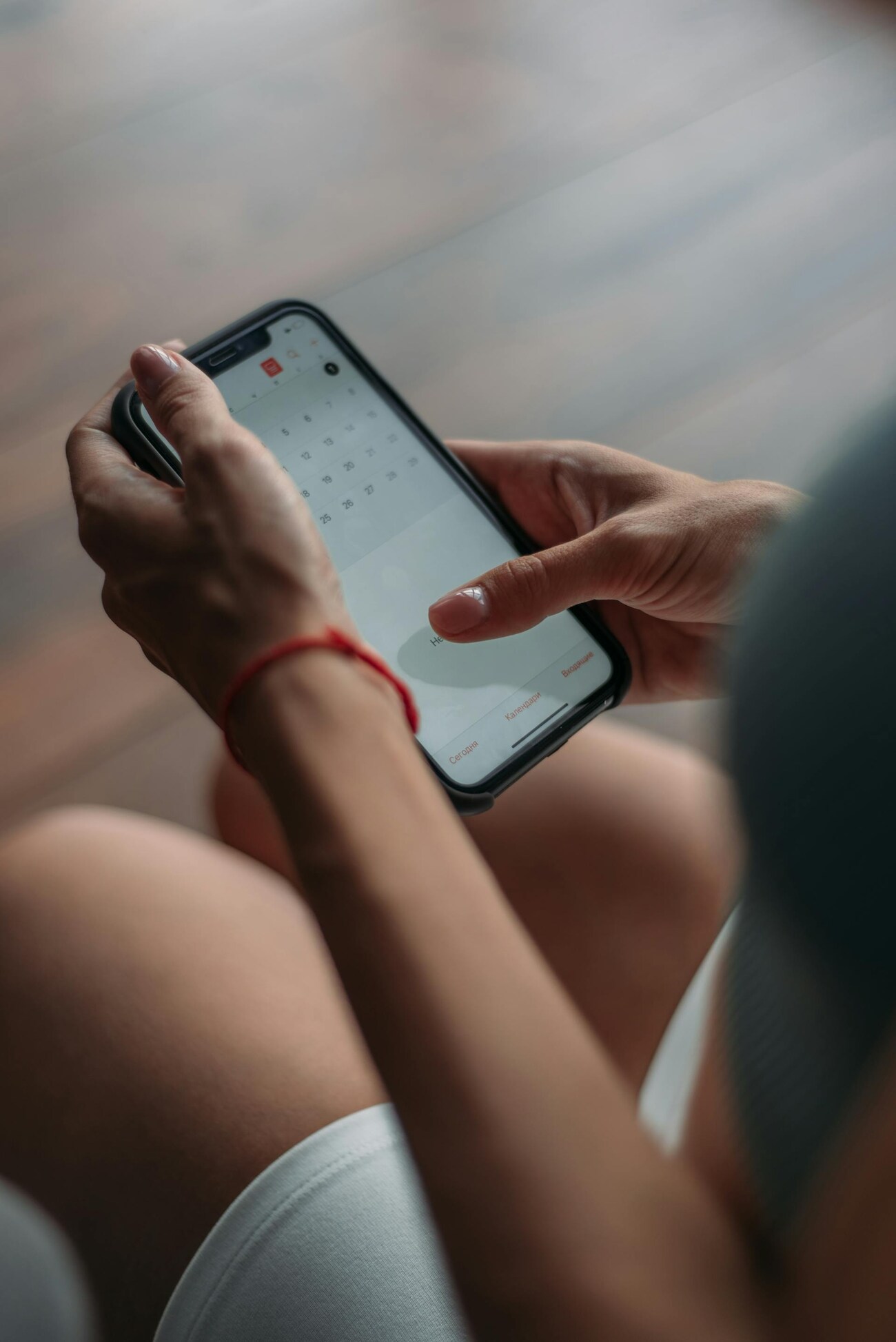 A woman checking her calendar on her phone, focused and engaged in planning her schedule