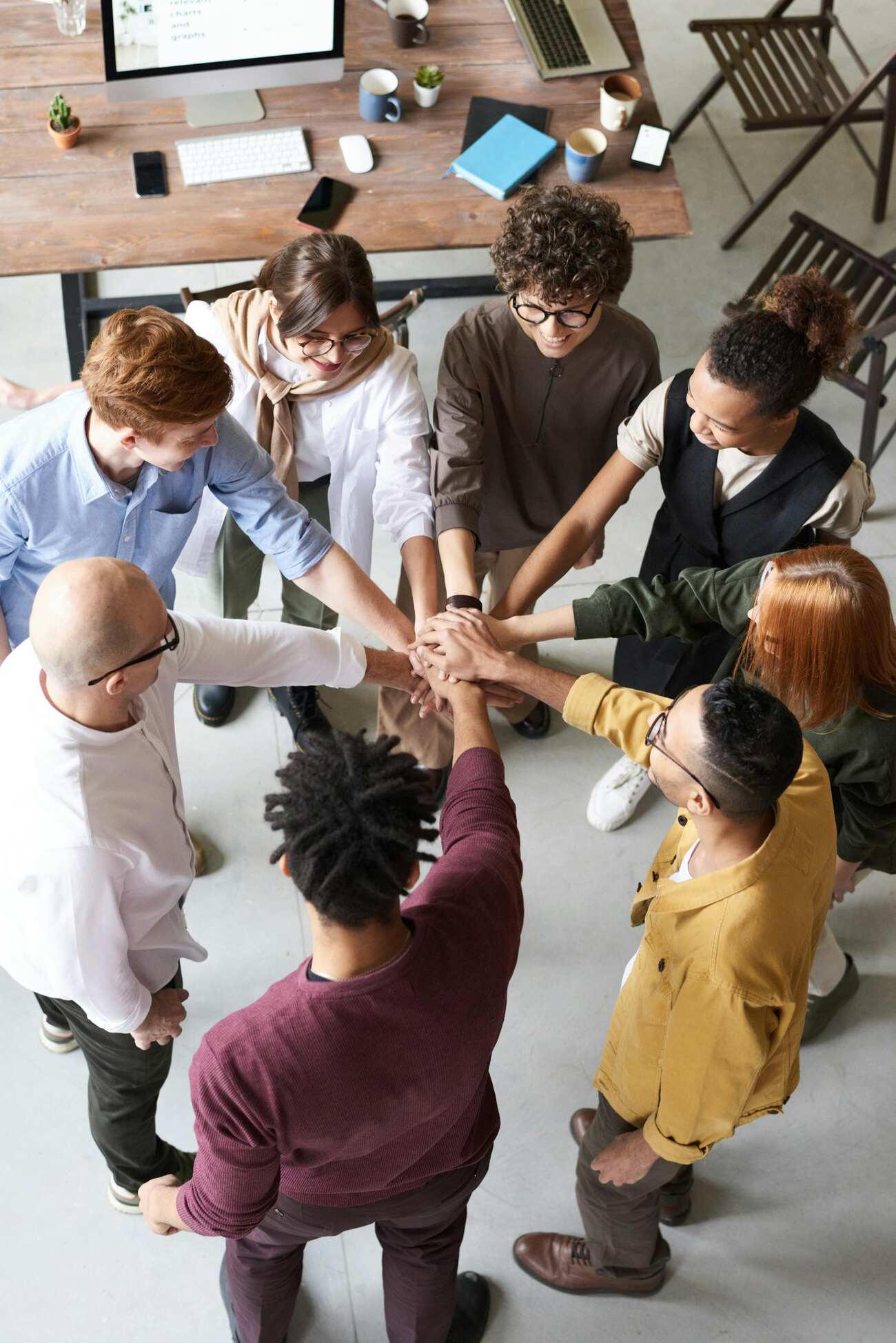 A circle of individuals from various backgrounds, holding hands together
